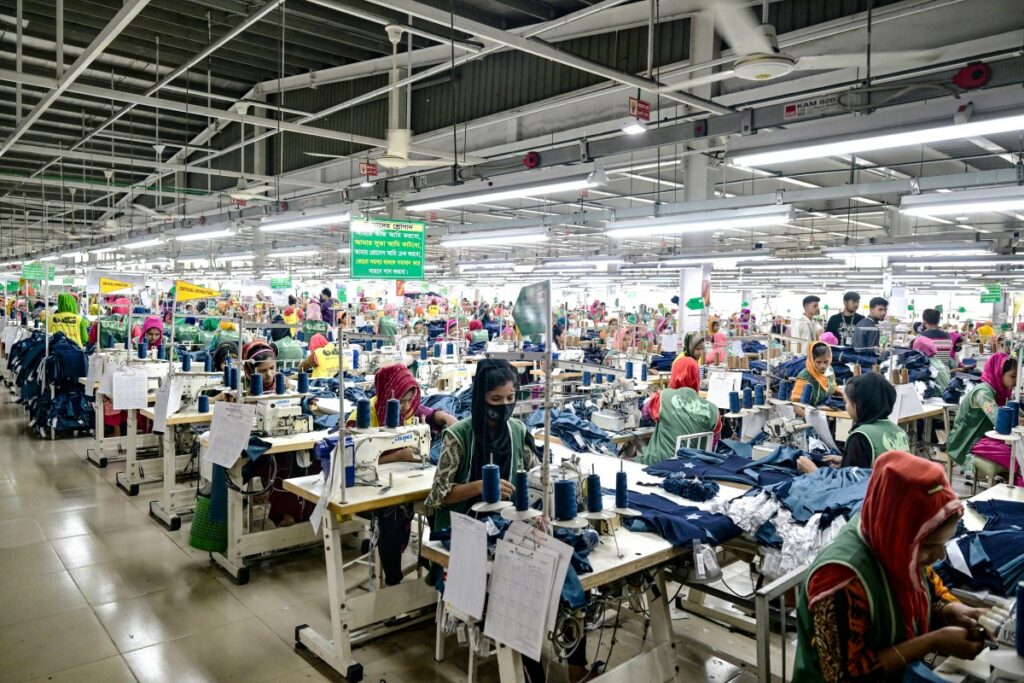 Trabajadores de la confección sastran ropa en sus estaciones de costura en una fábrica de ropa en Tongi, en las afueras de Daca, el 6 de julio de 2025.