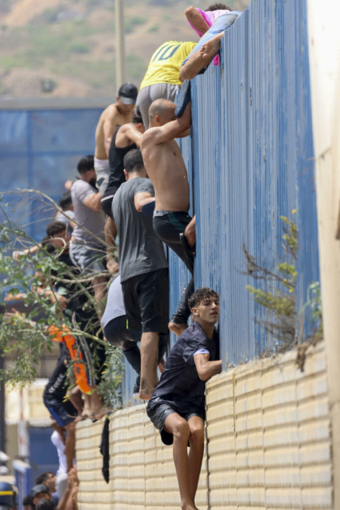 Miles de jóvenes marroquíes tratan de cruzar la valla fronteriza con Ceuta (España)